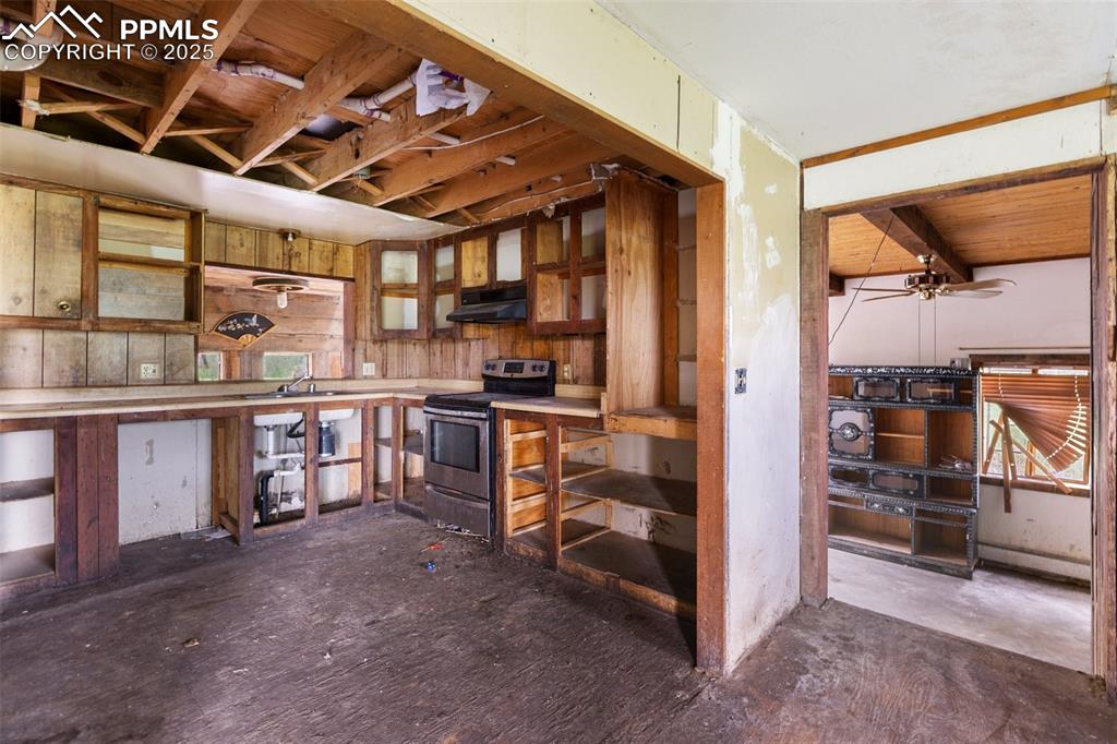 Image 8 of 36: Kitchen with stainless steel electric range and under cabinet range hood