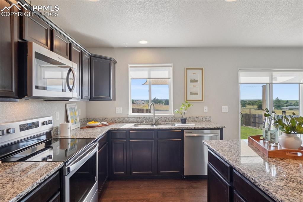 Image 10 of 46: Kitchen featuring appliances with stainless steel finishes, a textured ceil