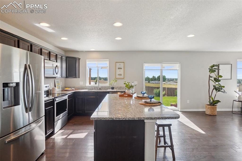 Image 12 of 46: Kitchen with appliances with stainless steel finishes, a textured ceiling, 