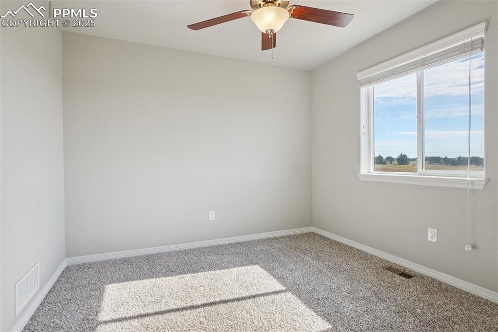 Image 19 of 46: Empty room with carpet and a ceiling fan