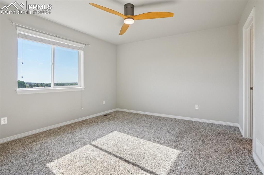 Image 20 of 46: Empty room with carpet and a ceiling fan