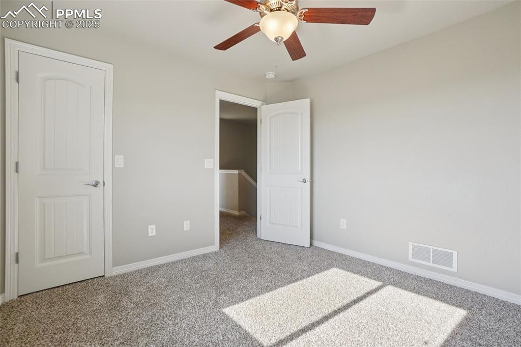 Image 25 of 46: Unfurnished bedroom with carpet flooring and ceiling fan
