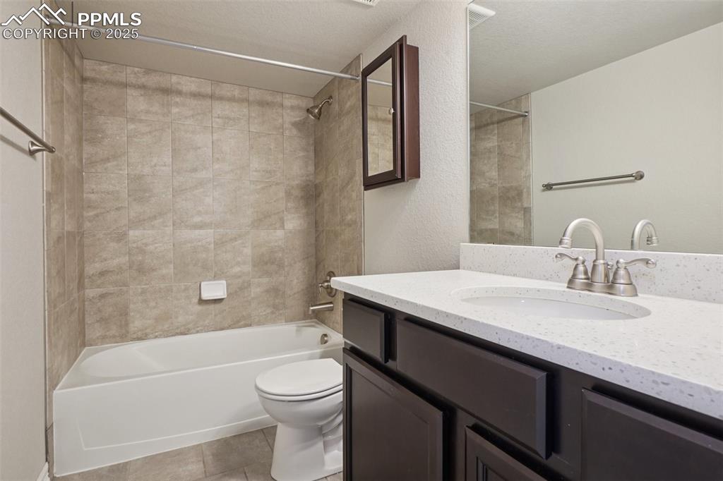 Image 29 of 46: Full bath with vanity, tub / shower combination, tile patterned flooring, a