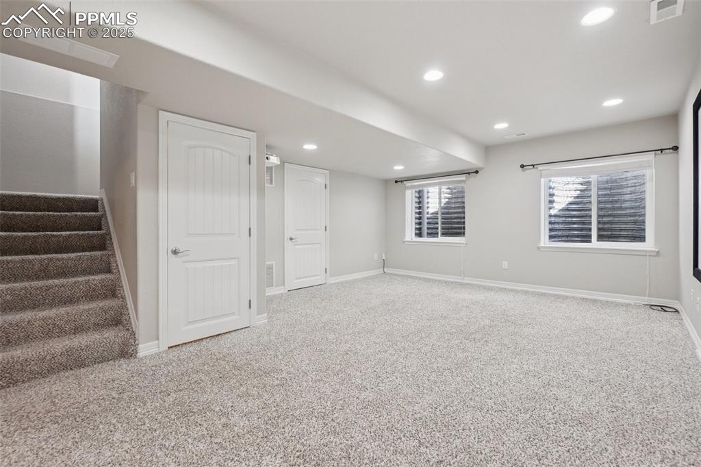 Image 37 of 46: Basement featuring stairs, recessed lighting, and carpet floors