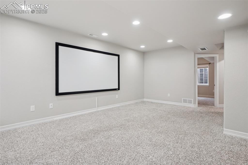 Image 38 of 46: Carpeted home theater room with recessed lighting and baseboards