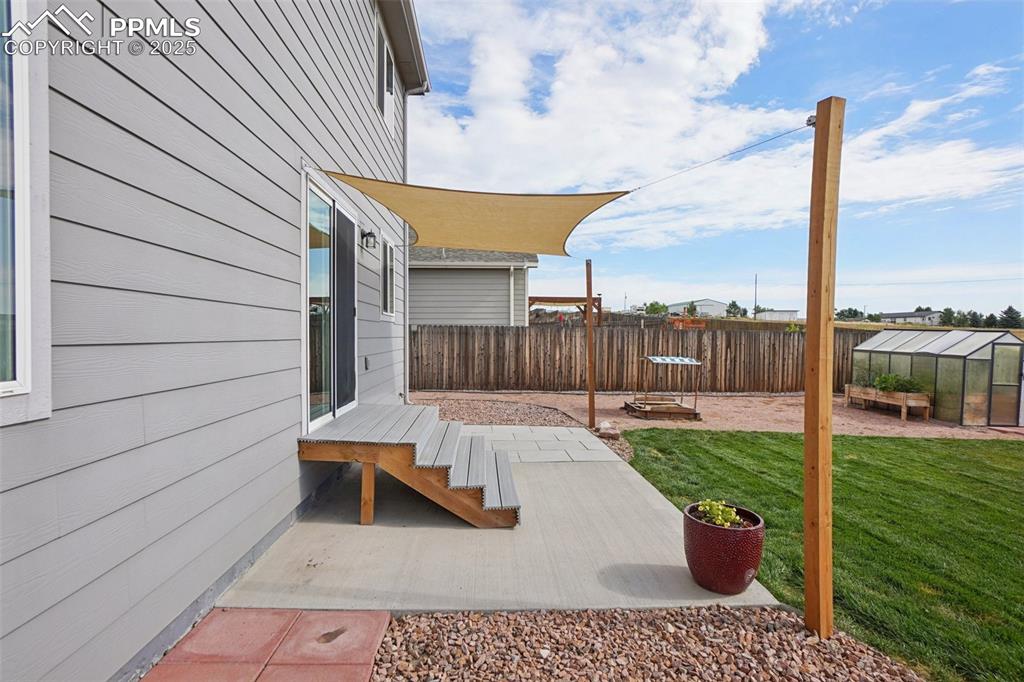 Image 39 of 46: Fenced backyard with an exterior structure, an outbuilding, and a patio