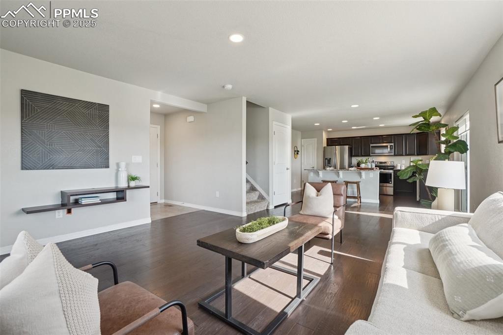 Image 4 of 46: Living area featuring recessed lighting, wood finished floors, and stairway
