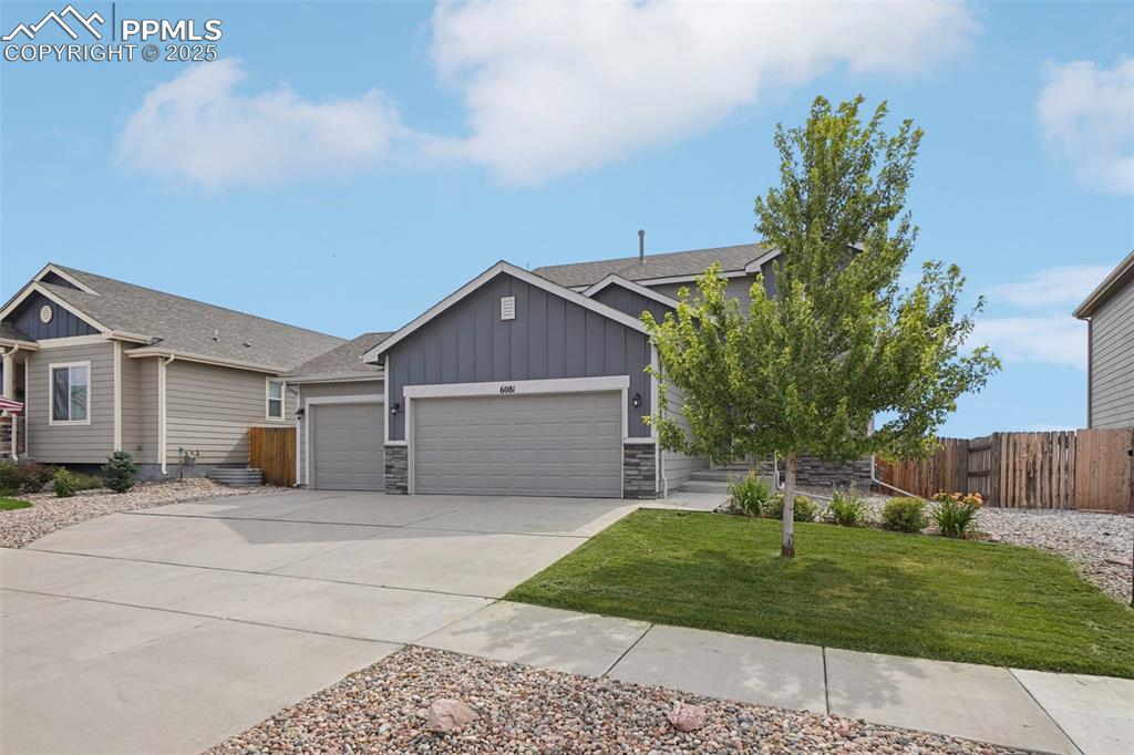 Image 45 of 46: View of front of home featuring board and batten siding, stone siding, a ga
