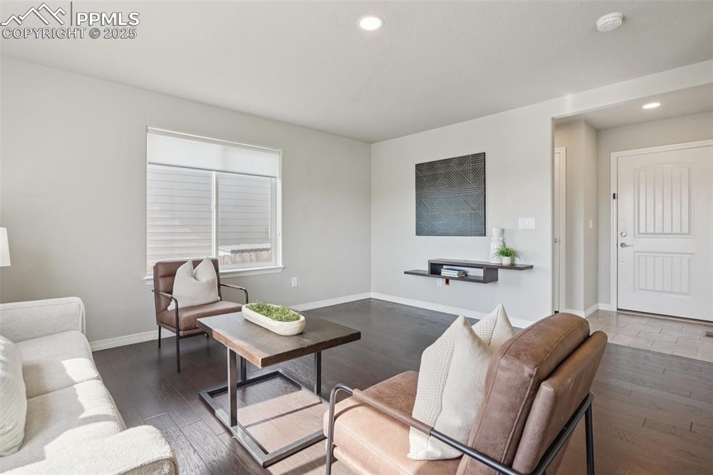 Image 6 of 46: Living area with wood finished floors and recessed lighting