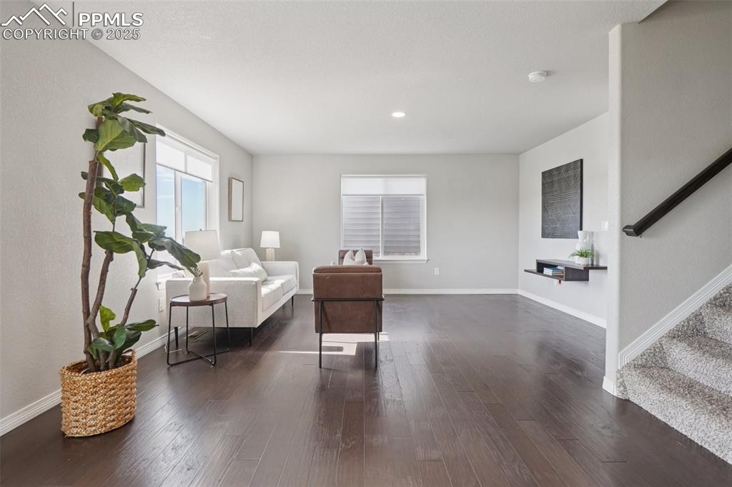 Image 7 of 46: Sitting room featuring stairway, dark wood-style flooring, and recessed lig