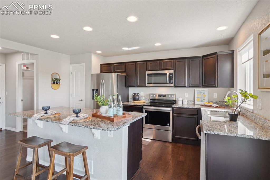 Image 9 of 46: Kitchen featuring appliances with stainless steel finishes, dark wood-style