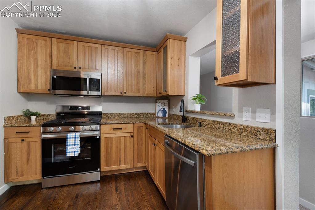 Image 11 of 33: Kitchen featuring stainless steel appliances, light stone countertops, and 