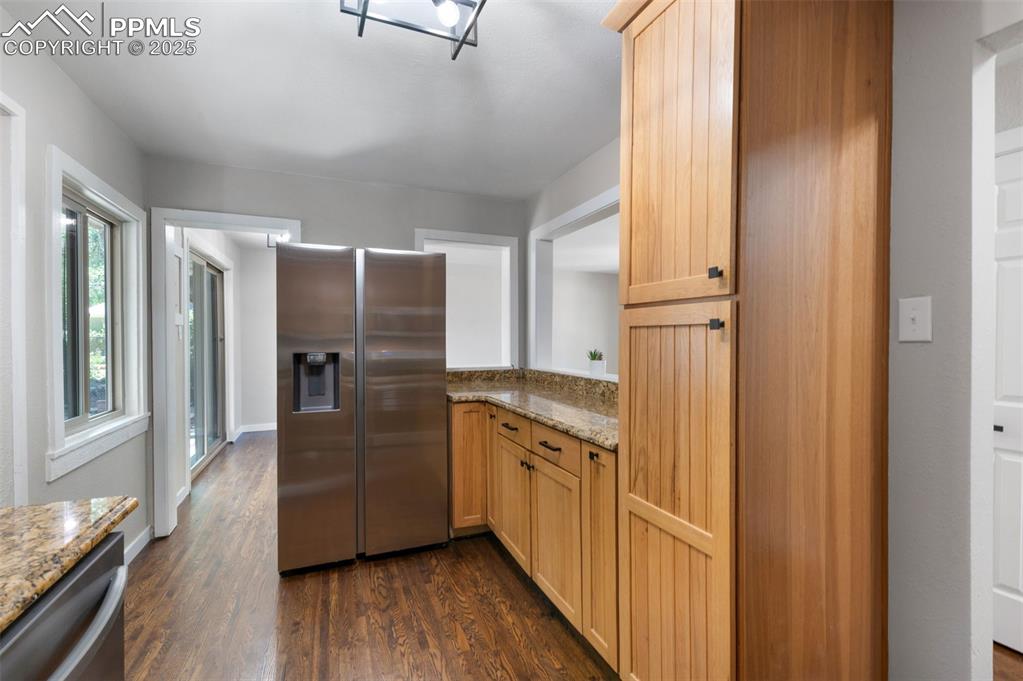 Image 13 of 33: Kitchen with appliances with stainless steel finishes, dark wood-type floor