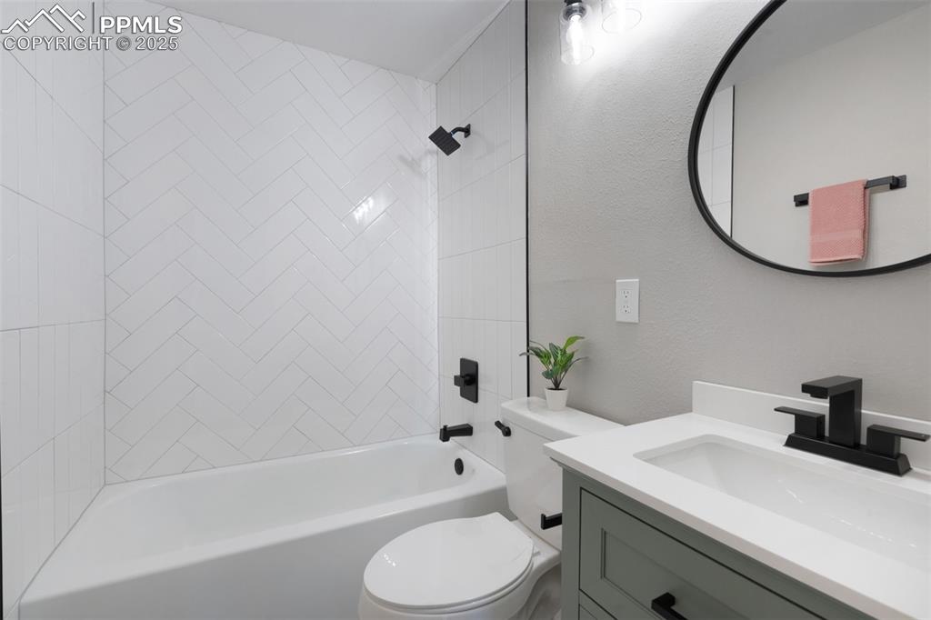 Image 20 of 33: Full bath featuring shower / washtub combination, vanity, and a textured wa