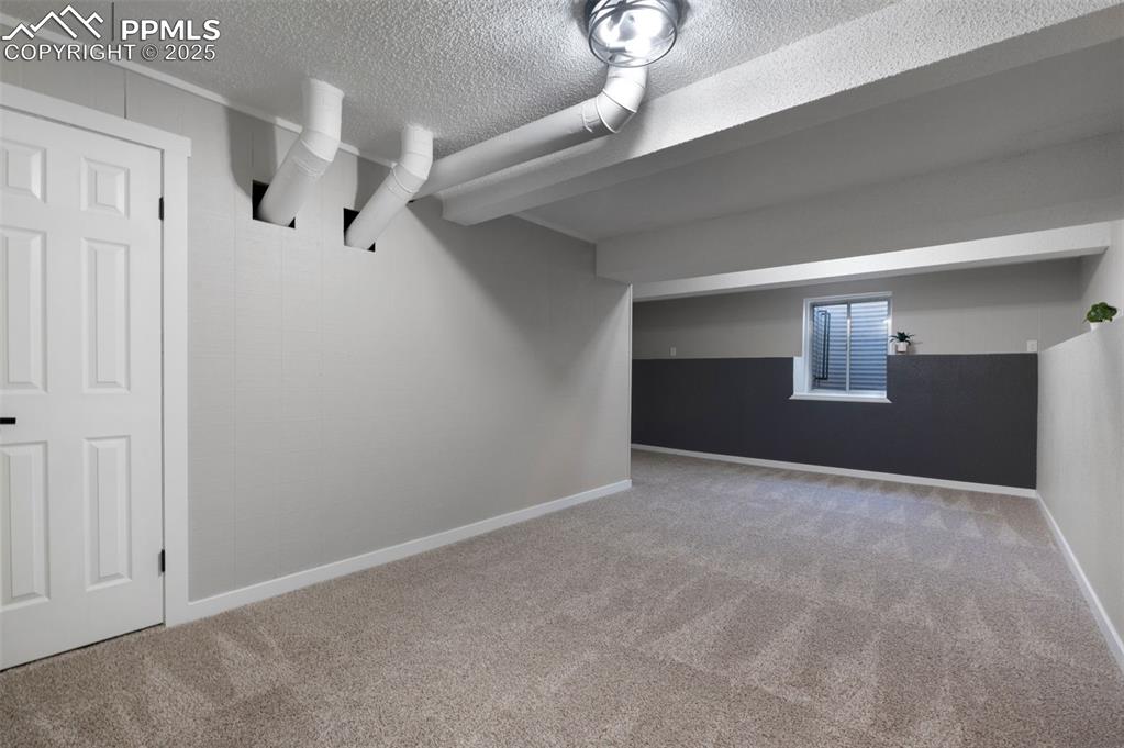 Image 23 of 33: Finished below grade area with carpet and a textured ceiling