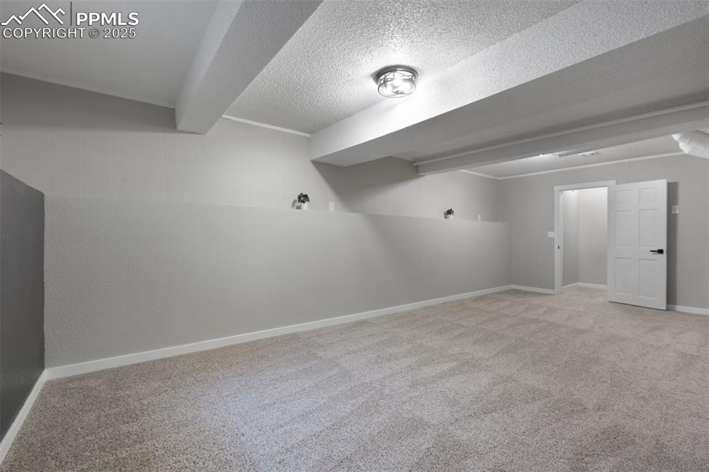 Image 25 of 33: Finished below grade area featuring light colored carpet and a textured cei