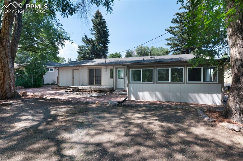 Image 29 of 33: Rear view of house featuring a shingled roof and a patio area