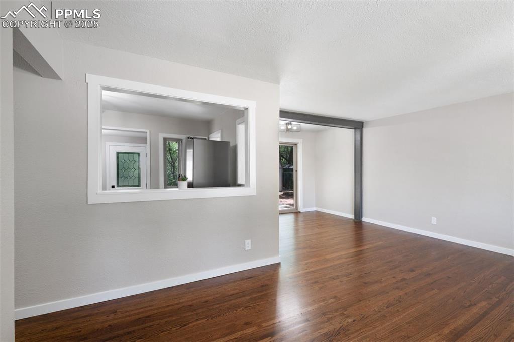 Image 4 of 33: Spare room with dark wood finished floors and a textured ceiling