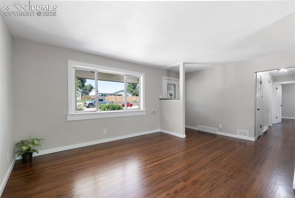 Image 6 of 33: Spare room with dark wood-style flooring and a textured ceiling