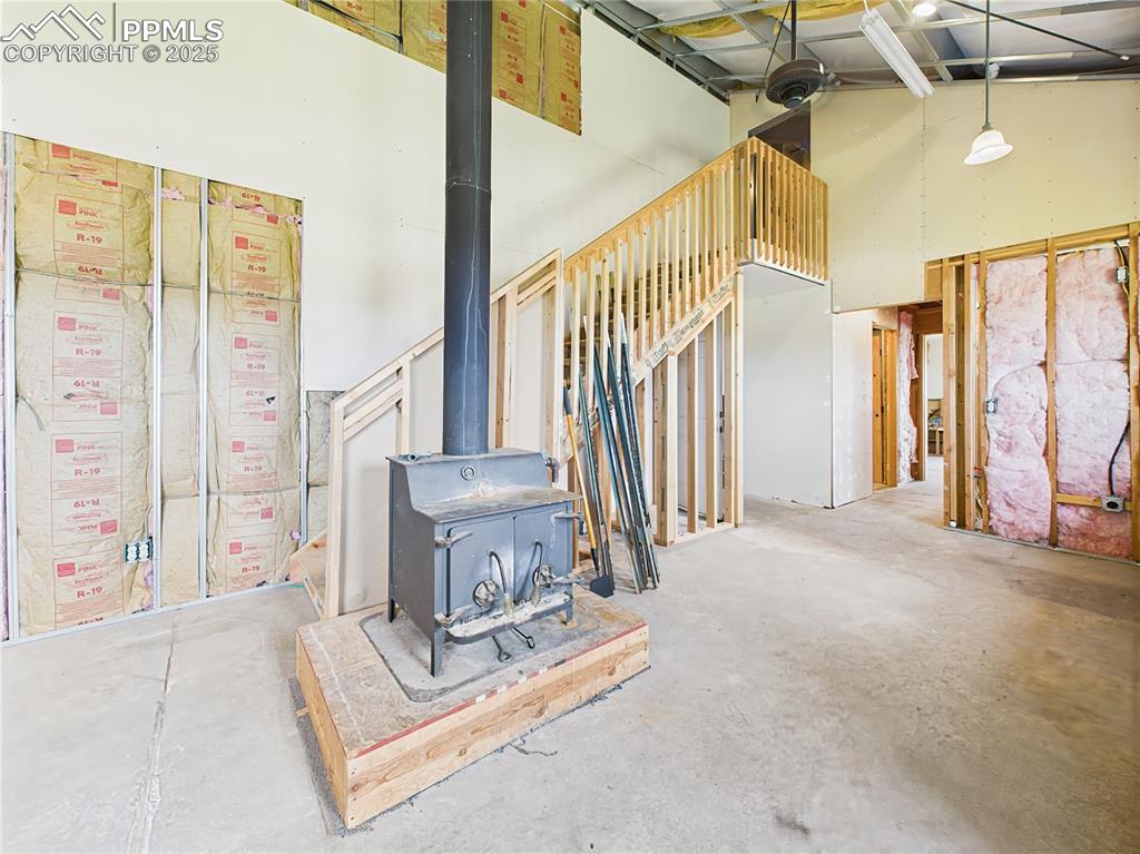Image 18 of 50: wood-burning stove and stair access, ideal for a future sitting or gatherin