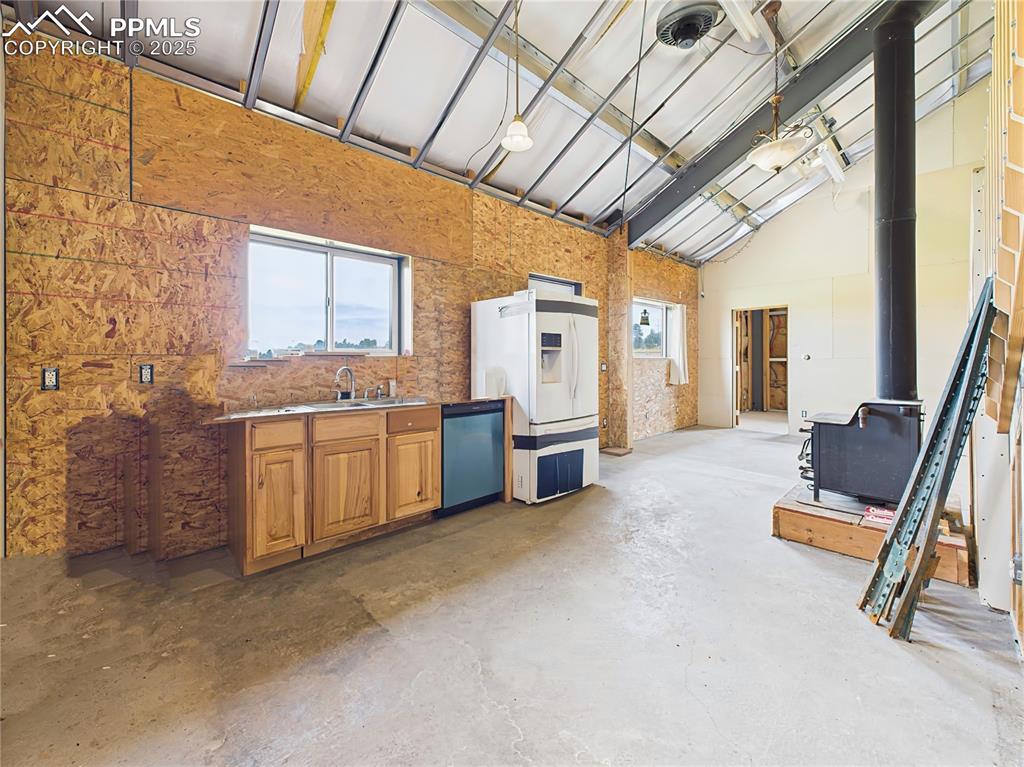 Image 19 of 50: Kitchenette – Basic kitchen setup includes  lower cabinets, sink, and dishw