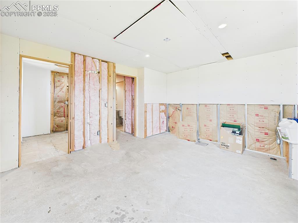 Image 23 of 50: Unfinished Interior Room – Large space with partial drywall, insulation, an