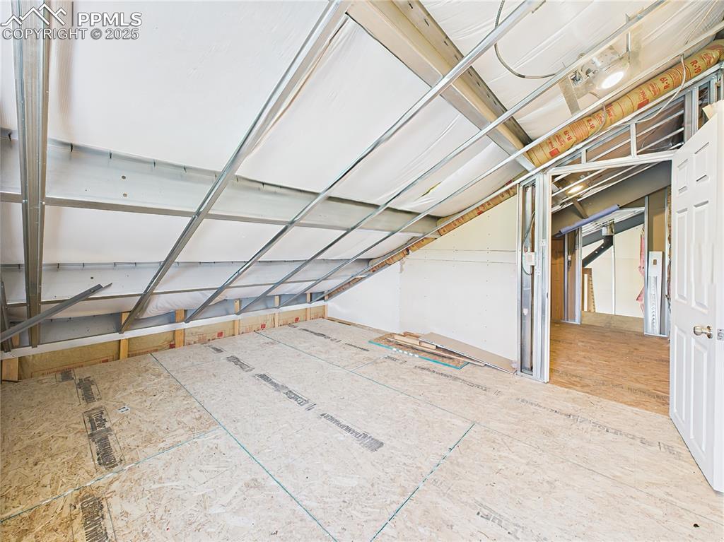 Image 27 of 50: Upper-Level Flex Room – A spacious loft-style room with sloped ceilings, st