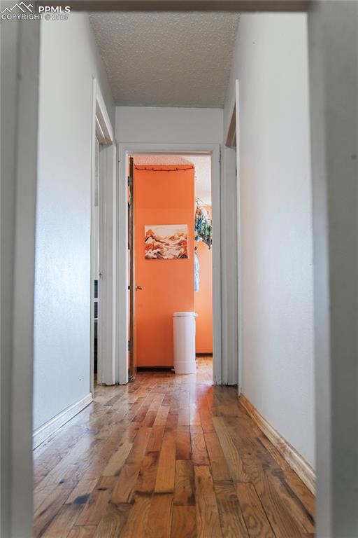 Image 11 of 23: Hall featuring wood-type flooring and a textured ceiling