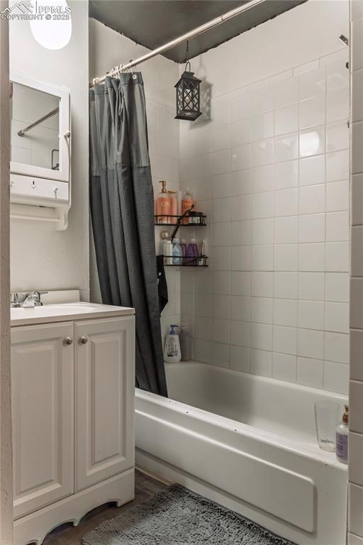 Image 16 of 23: Bathroom with vanity and shower / bathtub combination with curtain