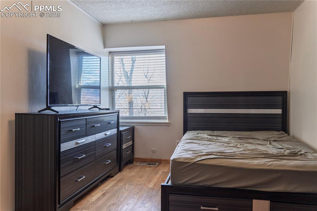 Image 18 of 23: Bedroom featuring light wood-style flooring and a textured ceiling