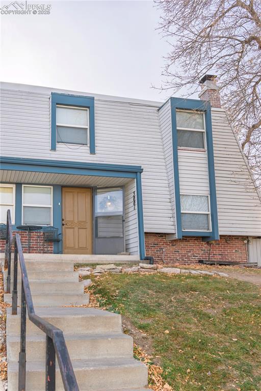 Image 2 of 23: View of front of home featuring a chimney and covered porch