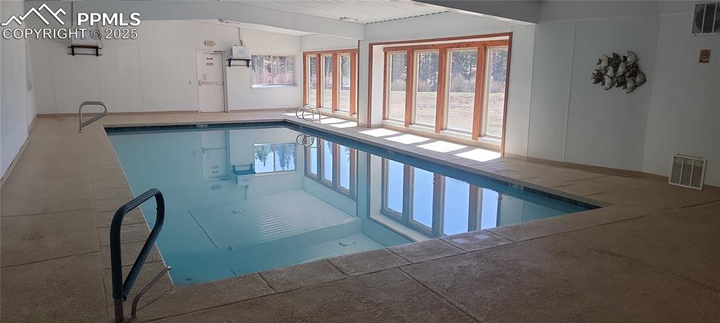 Image 16 of 21: Indoor pool featuring a sunroom