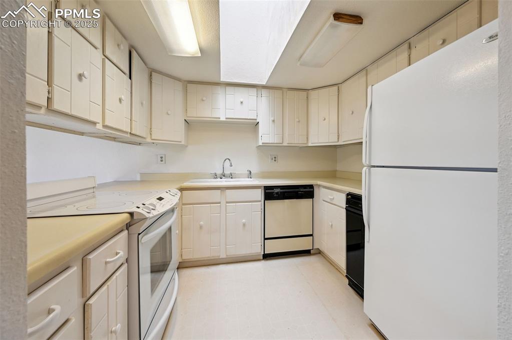 Image 13 of 32: The kitchen also includes a refrigerator, trash compactor, and skylight.