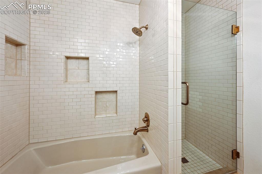 Image 18 of 32: This full-size bathroom has a separate shower and tub area with cut-outs.