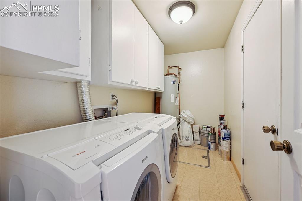 Image 20 of 32: The laundry area includes extra cabinets and access to the crawl space. 
