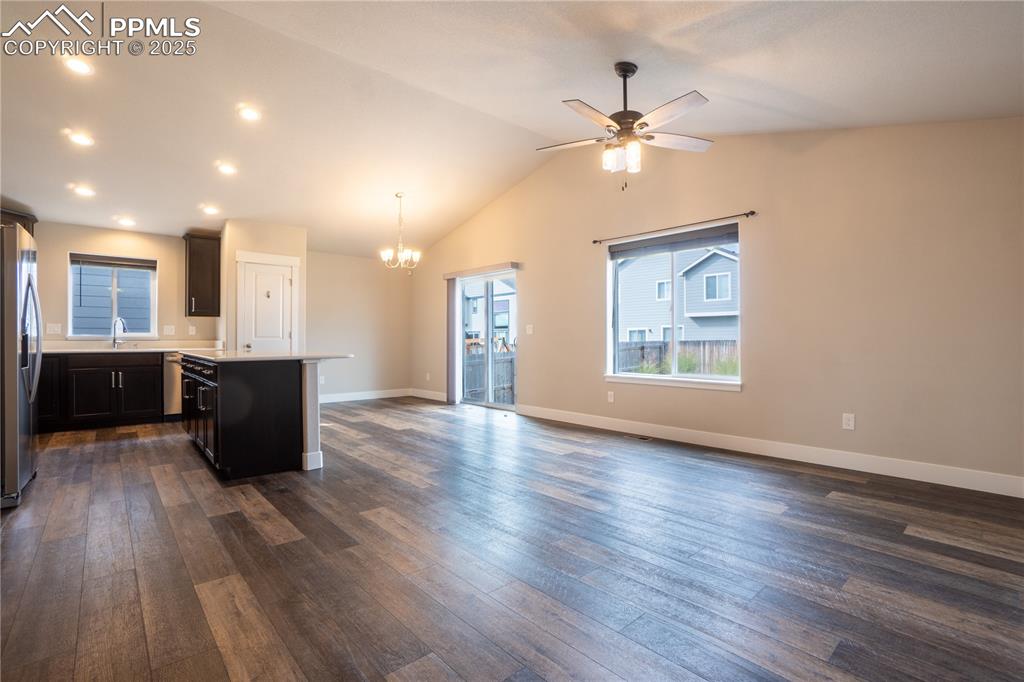 Image 10 of 35: Kitchen with open floor plan, a center island, dark wood finished floors, l