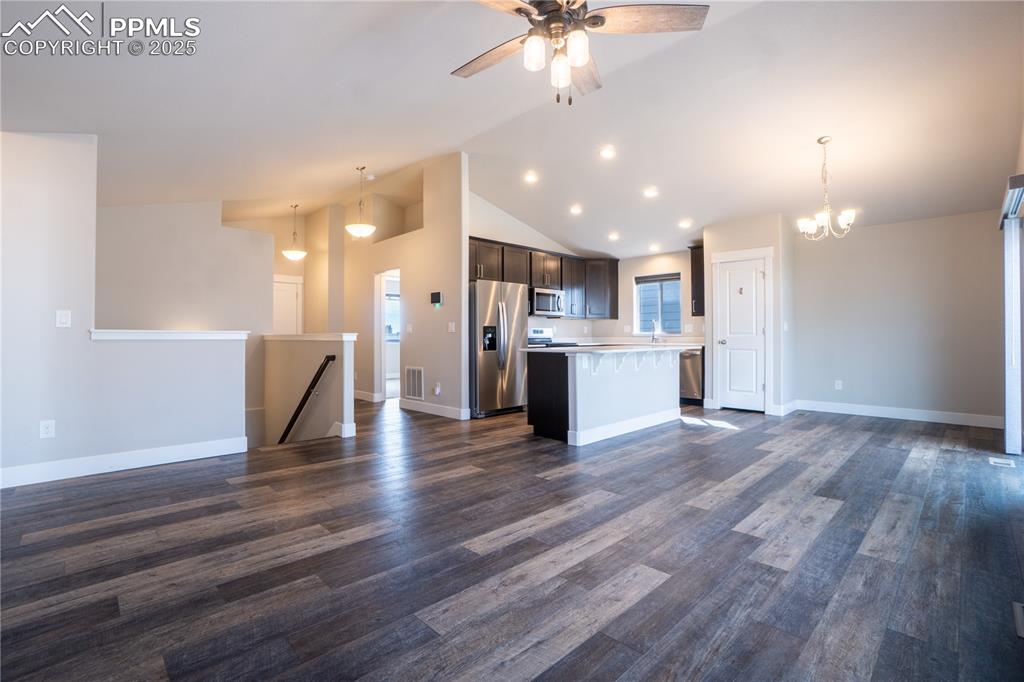 Image 11 of 35: Kitchen with open floor plan, light countertops, hanging light fixtures, ap