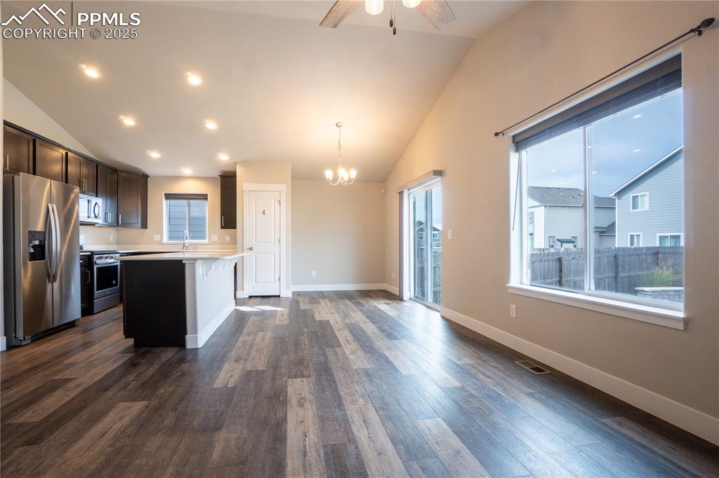 Image 12 of 35: Kitchen featuring stainless steel appliances, light countertops, a chandeli