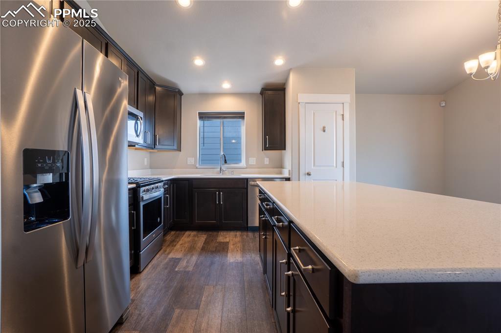 Image 15 of 35: Kitchen featuring stainless steel appliances, dark wood finished floors, re