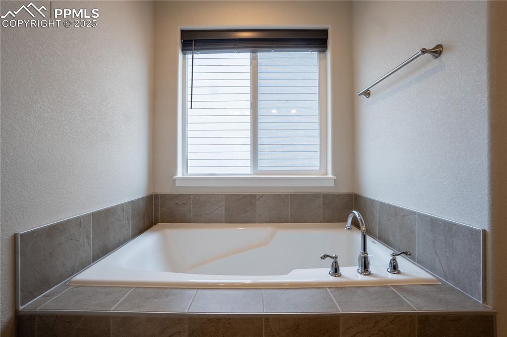 Image 23 of 35: Full bath featuring a textured wall and a garden tub