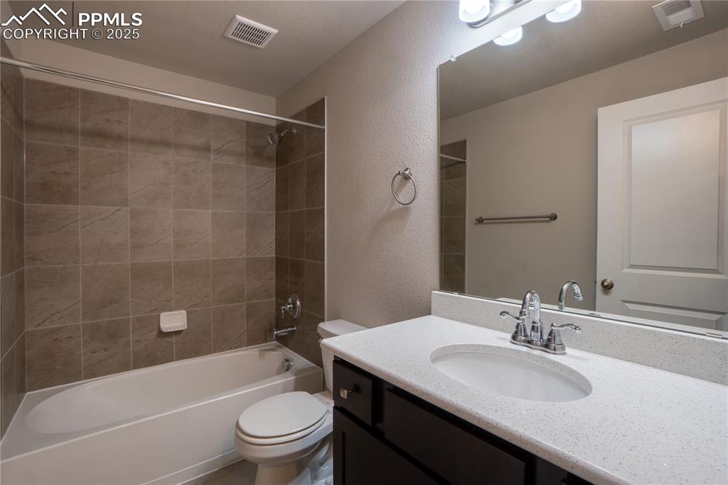 Image 25 of 35: Full bathroom featuring a textured wall, shower / washtub combination, and