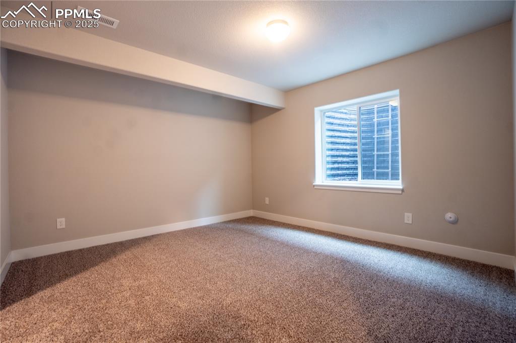 Image 26 of 35: Carpeted spare room with baseboards