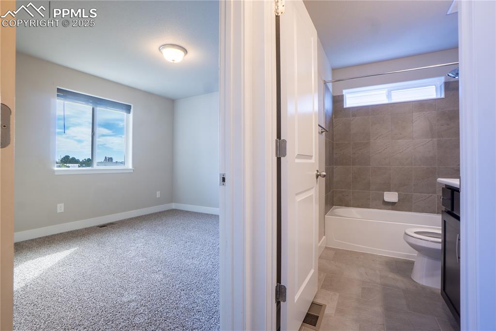 Image 6 of 35: Bathroom with bathing tub / shower combination, vanity, and light carpet