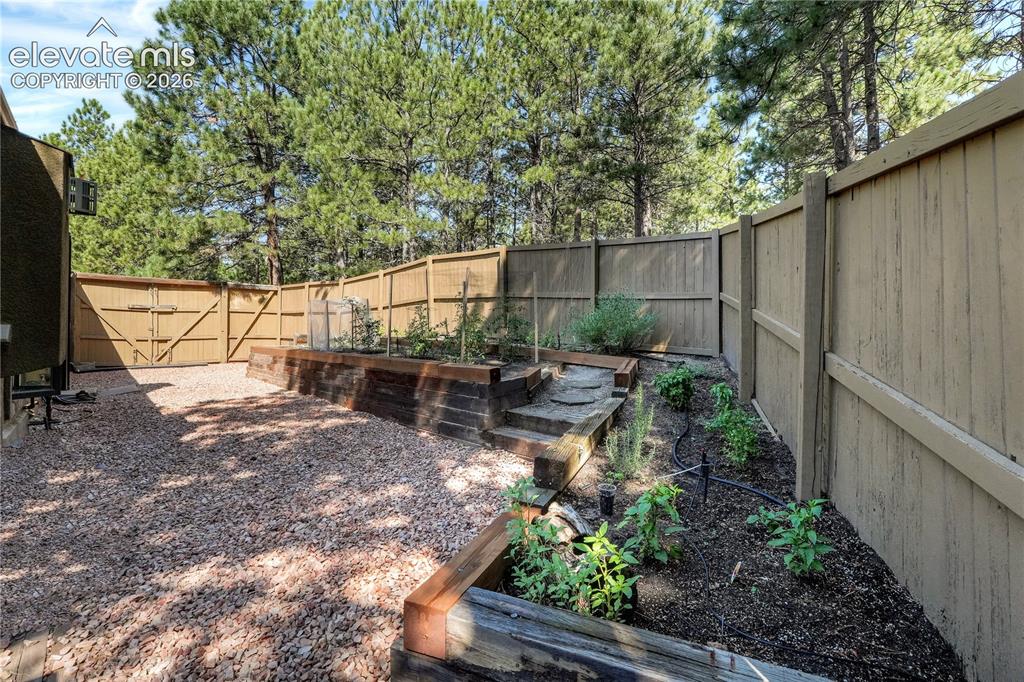 Image 34 of 46: Side yard has dog run & raise garden beds