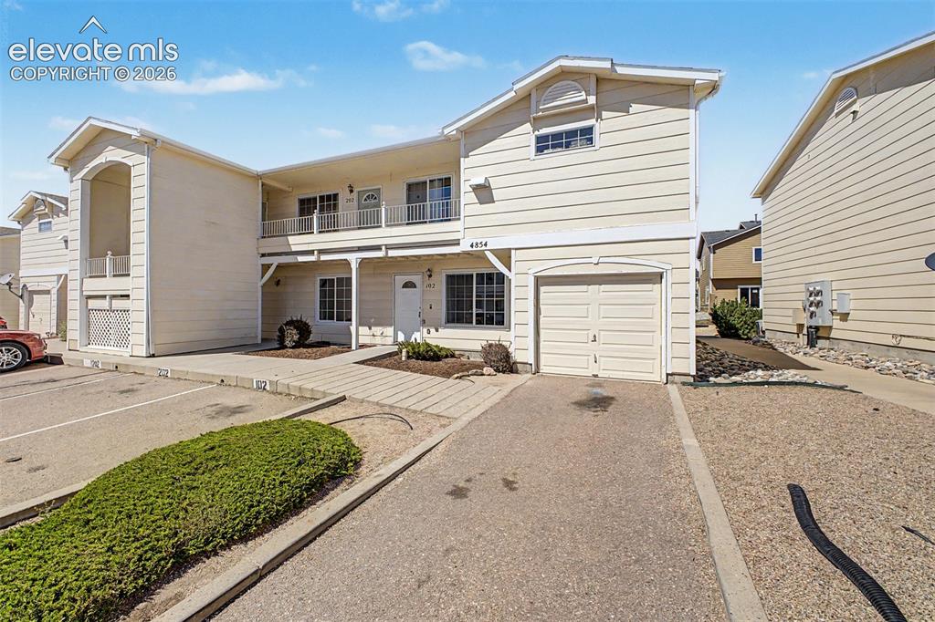 Image 3 of 32: Attached garage with additional driveway parking, plus assigned space