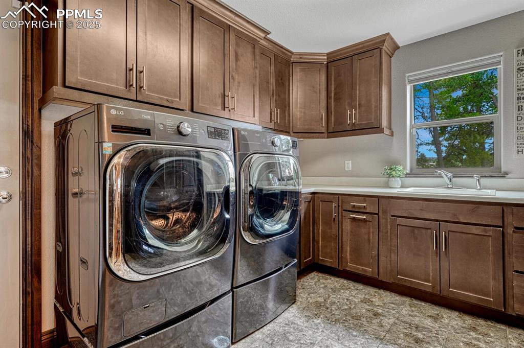 Image 15 of 50: Washroom featuring cabinet space and washing machine and dryer