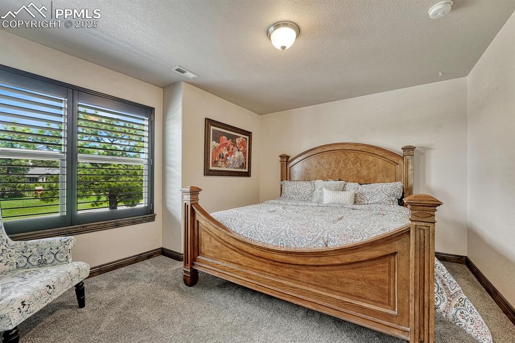 Image 23 of 50: Bedroom featuring carpet flooring, baseboards, and a textured ceiling