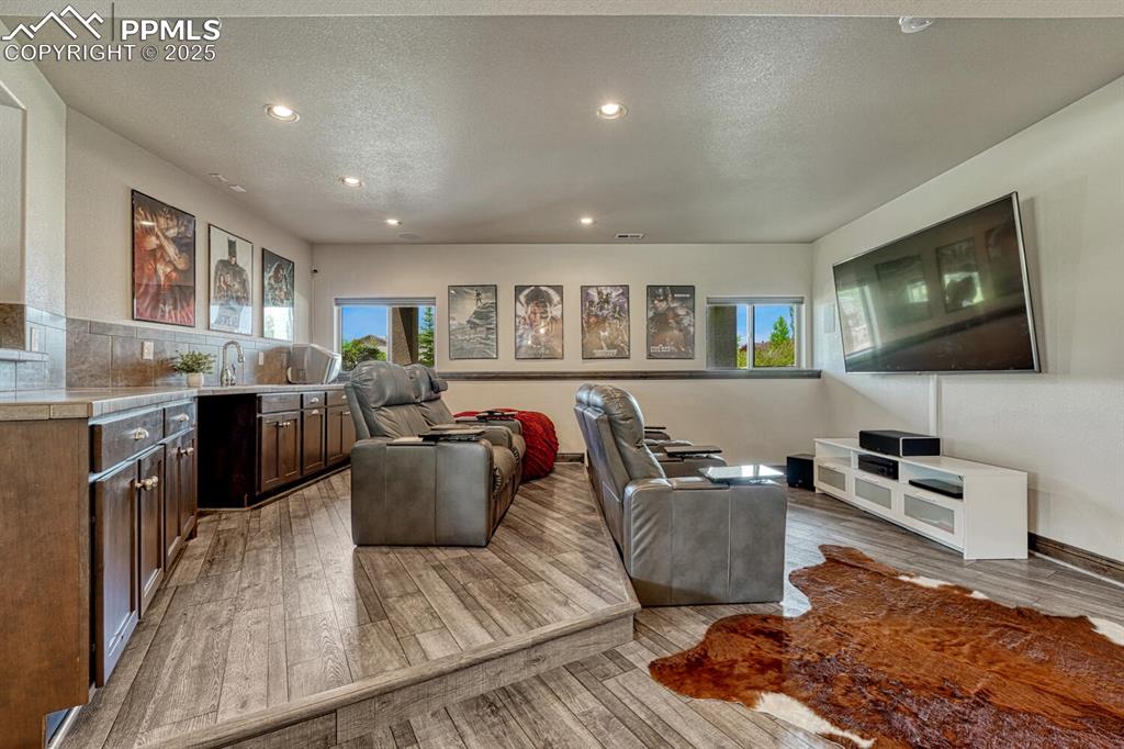 Image 30 of 50: Living room featuring light wood finished floors, recessed lighting, and a 
