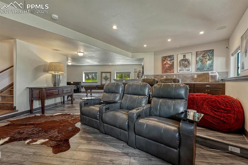 Image 32 of 50: Home theater room with wood finished floors, recessed lighting, a textured 