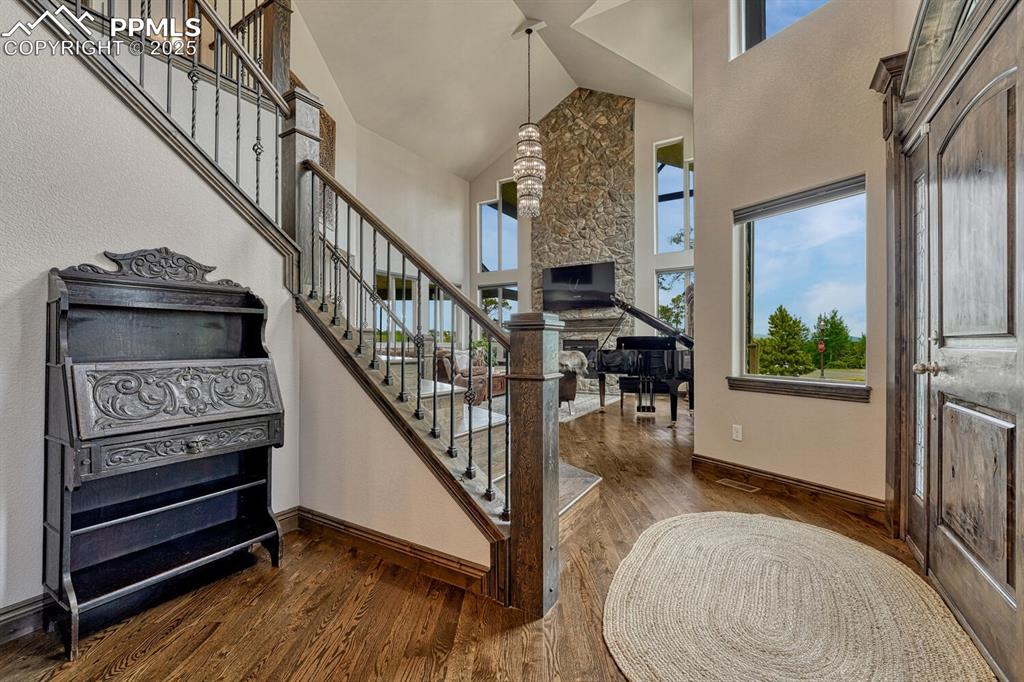 Image 4 of 50: Foyer with high vaulted ceiling, plenty of natural light, dark wood-style f